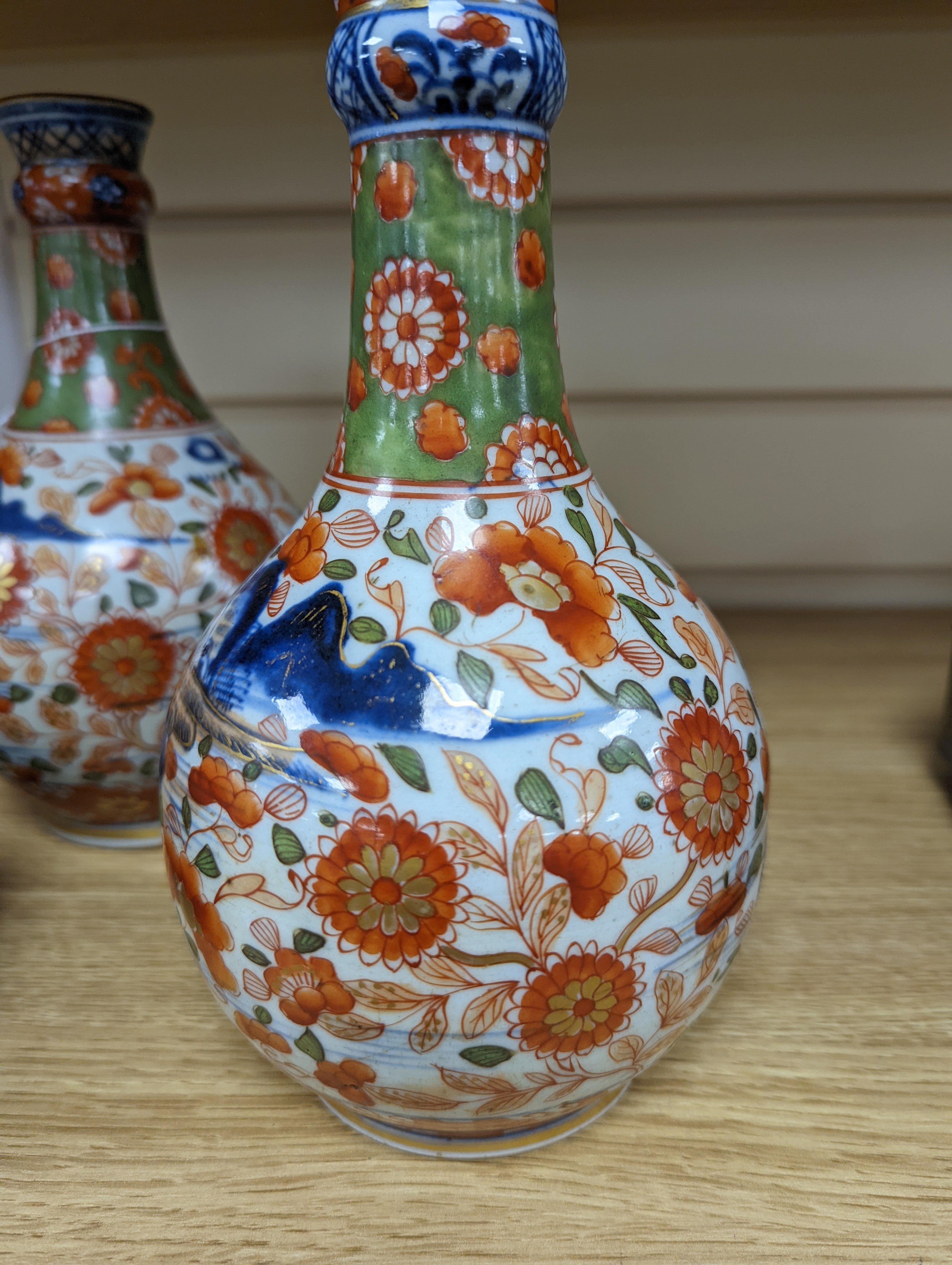 A pair of 18th century Chinese clobbered blue and white bottle vases 23cm